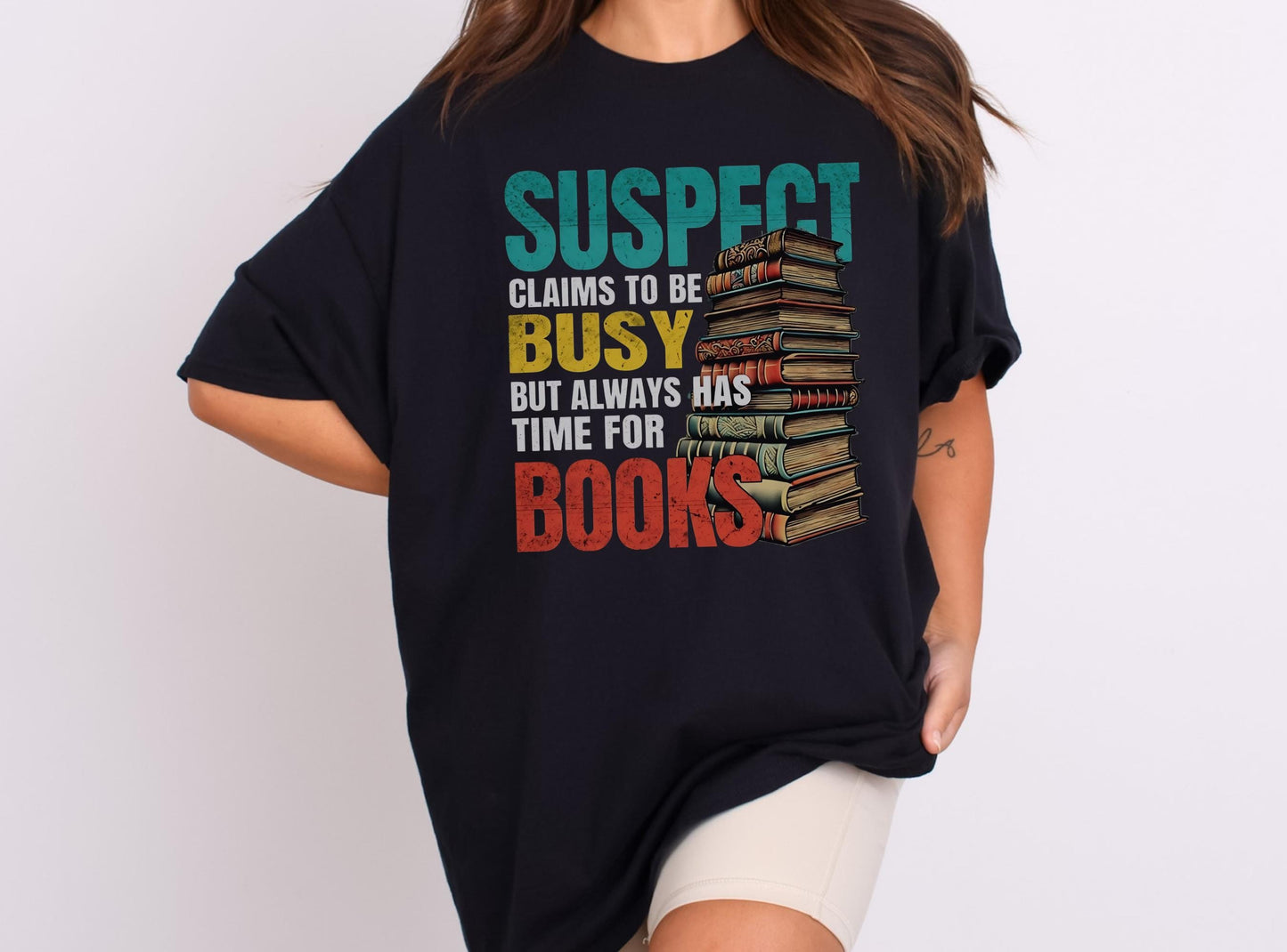 Suspect Claims to be busy but always has time for books Black oversized T-shirt,retro multi color text with an illustration of a stack of books